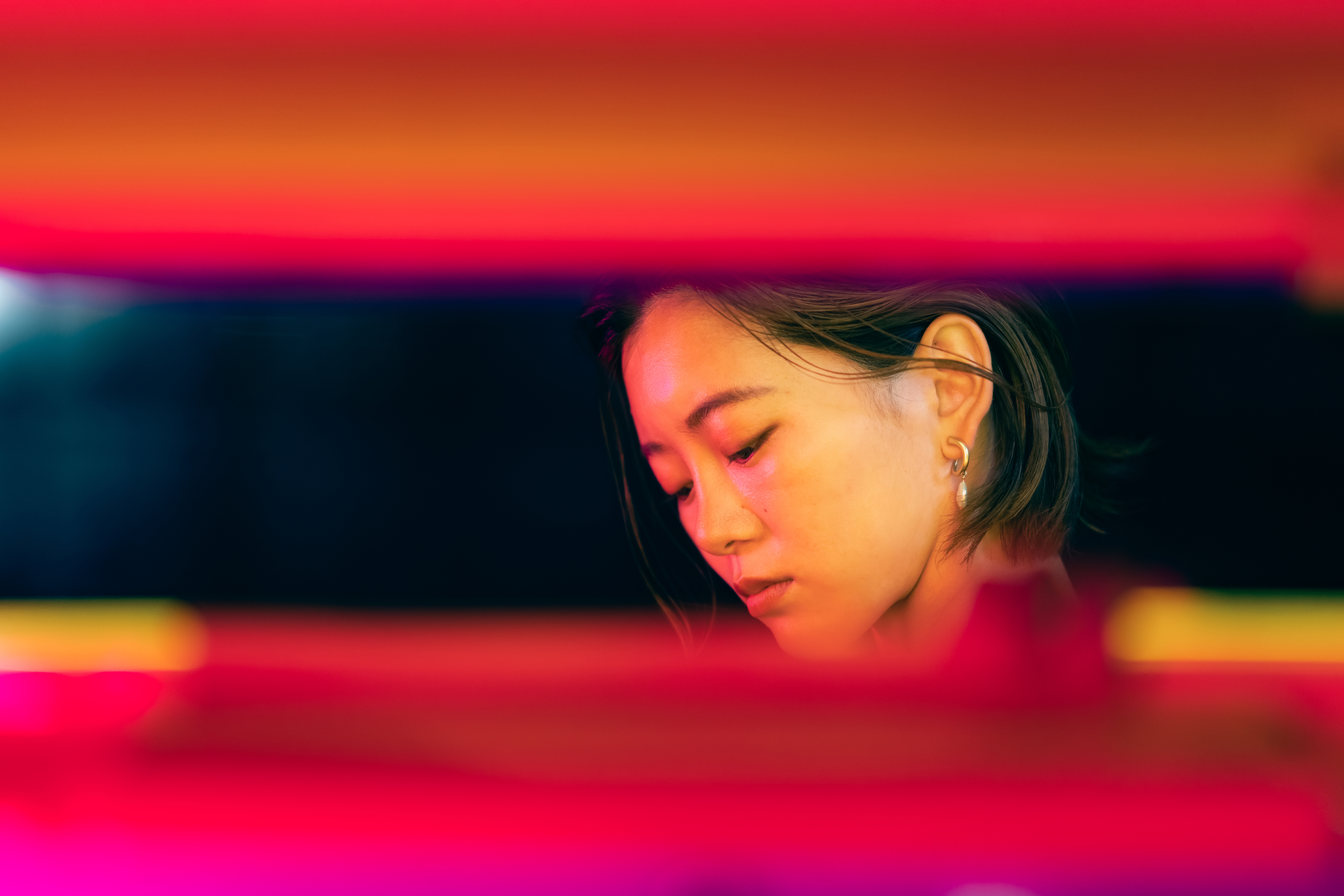 Portrait of beautiful young woman lit by neon lights in dark