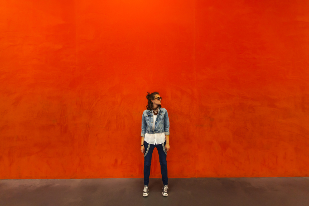 Woman walking in front of red background